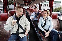 Gut gesichert: Marco Schäfermann (links) und Martina Wallbaum von Hänschen’s Reisedienst haben es sich für das Foto auf den Passagierplätzen bequem gemacht und sich mit den Dreipunktgurten angeschnallt. Im Hintergrund studiert Firmenchef Rolf Wieneke den aktuellen Reisekatalog.  - © Foto: Preuss