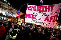 Menschen nehmen an der Kundgebung «Brandmauer statt Brandstiftung» von Amnesty International, Seebrücke und anderen Organisationen mit einem Transparent mit der Aufschrift «Asylrecht verteidigen Merz und AfD abschaffen» vor der CDU-Zentrale in Berlin teil. - © Fabian Sommer/dpa