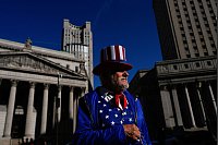 Ein als Onkel Sam verkleideter Demonstrant nimmt an einem Protest auf dem Foley Square in New York anlässlich des Aktionstages für die Hochschulbildung teil. - © Julia Demaree Nikhinson/AP/dpa