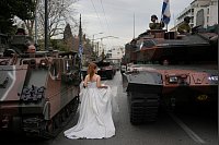 Unabhängigkeitstag in Griechenland: Ein als Braut gekleidetes Model geht zwischen Panzern während eines Fotoshootings vor einer Militärparade zum Gedenken an den Beginn des griechischen Unabhängigkeitskrieges von 1821 gegen die 400-jährige osmanische Herrschaft vorbei. - © Thanassis Stavrakis/AP/dpa