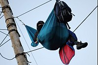 Ein Aktivist am Morgen des dritten Tages der Räumung des von Klimaaktivisten besetzten Braunkohleorts Lützerath in seiner Hängematte. - © Rolf Vennenbernd/dpa