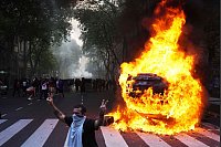 Ein Auto brennt in Buenos Aires während einer Demonstration von Fußballfans und Rentnern, die höhere Renten fordern und sich gegen die Sparmaßnahmen der Regierung von Präsident Milei wenden. - © Rodrigo Abd/AP/dpa