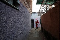 Ein als Weihnachtsmann verkleideter Mann verteilt Spielzeug an Kinder in einem als «COTA 905» bekannten Armenviertel in Caracas. - © Jeampier Arguinzones/dpa