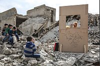 Anas Alkharboutli fotografierte einen Puppenspieler, der in den Trümmern ein Marionettentheater aufführt. - © Anas Alkharboutli/dpa