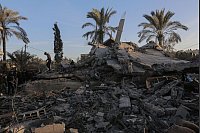 Palästinenser auf den Trümmern eines zerstörten Gebäudes im zentralen Gazastreifen. - © Omar Ashtawy/APA Images via ZUMA Press Wire/dpa