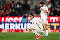 Kölns Damion Downs kniet nach der Partie auf dem Rasen. - © Marius Becker/dpa