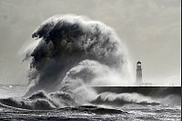 Große Wellen an der Mole vor dem Leuchtturm im Hafen von Seaham (England). - © Owen Humphreys/PA Wire/dpa