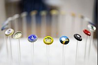 Kronenkorken sind am Stand des auf die Herstellung von Kronenkorken spezialisierten deutschen Unternehmens Brüninghaus auf der Getränkemesse BrauBeviale ausgestellt. - © Daniel Karmann/dpa