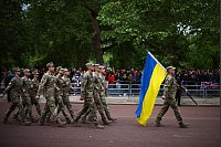 Mitglieder der ukrainischen Streitkräfte marschieren während der Parade anlässlich des 80. Jahrestags des Victory in Europe Day mit einer ukrainischen Fahne in London. - © Henry Nicholls/Pool AFP/AP/dpa