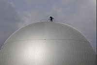 Nach den Olympischen Spielen - Ein Arbeiter steht auf der Spitze des olympischen Ballons - © Christophe Ena/AP/dpa