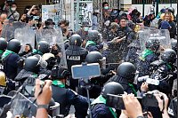 Demonstranten werfen w&auml;hrend eines Protests fermentierte Fischso&szlig;e in Richtung Bereitschaftspolizei. - &copy; Sarot Meksophawannakul/AP/dpa