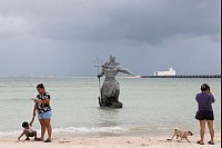 Schnappschüsse vor dem Sturm: Touristen fotografieren Poseidon-Skulptur, während sich Hurrikan 'Milton' auf Yucatan zubewegt - © Martin Zetina/AP/dpa