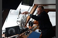 Scheibenwischer: Friedrich Merz, Kanzlerkandidat und Parteivorsitzender der CDU, wischt die Windschutzscheibe während der Fahrt mit einer Barkasse im Hamburger Hafen sauber. - © Marcus Brandt/dpa Pool/dpa
