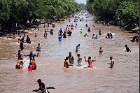 Menschen kühlen sich in Lahore bei heißem Wetter in einem Kanal ab. - © K.M. Chaudary/AP/dpa