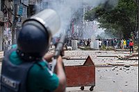 Die Polizei feuert Tränengasgranaten ab, um protestierende Studenten zu vertreiben. - © Rajib Dhar/AP/dpa