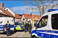 Polizeibeamte sichern die Umgebung um einen Tatort im thüringischen Klettbach, wo vier Menschen tot aufgefunden worden waren. - © Katrin Zeiss/dpa