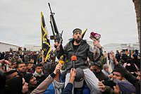 Der freigelassene palästinensische Häftling Hatem Kaider, 39, hält ein Gewehr und Blumen in der Hand, als er von einer jubelnden Menschenmenge im Gazastreifen begrüßt wird nach seiner Entlassung aus einem israelischen Gefängnis. - © Abdel Kareem Hana/AP/dpa