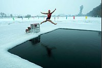 Mutig ins Eis: Yu Xiaofeng taucht im gefrorenen Songhua - © Andy Wong/AP/dpa