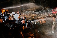 Auch Pfefferspray kommt zum Einsatz. - © Khalil Hamra/AP/dpa