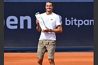 Mit Pokal und Lederhose: Alexander Zverev bejubelt seinen Sieg beim ATP-Turnier in München. - © Sven Hoppe/dpa
