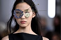 Ein Model präsentiert eine "blumige" Kreation von Issey Miyake bei der Vorführung der Spring-Summer 2025 Kollektion. - © Julien De Rosa/AFP/dpa