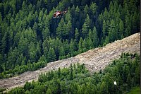 Ein Helikopter der Air Zermatt fliegt über einer Alp. - © Jean-Christophe Bott/KEYSTONE/dpa