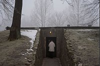 Eine Person betritt eine Gaskammer und ein Krematorium im ehemaligen nationalsozialistischen deutschen Konzentrations- und Vernichtungslager Auschwitz-Birkenau. - © Oded Balilty/AP/dpa