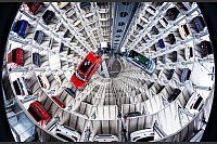 Volkswagen: Ein Volkswagen Tiguan (l) und ein Volkswagen ID.7 (r) werden in einem der beiden Autotürme der Volkswagen Autostadt aus Boxen gehoben. - © Moritz Frankenberg/dpa