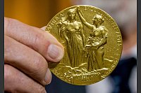 Die Rückseite der Nobel-Medaille für Physik stellt die Natur in Form einer Göttin dar, die ein Füllhorn hält. Der Schleier, der ihr Gesicht bedeckt, wird vom Genie der Wissenschaft hochgehalten. (Archivbild) - © Stefanie Loos/AP-Pool/dpa