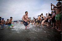 Viel Spaß trotz Kälte haben die Teilnehmer beim "Eisbärenschwimmen" am Neujahrstag im kanadischen Vancouver. - © Ethan Cairns/The Canadian Press/AP/dpa