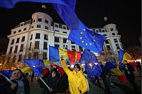 Menschen schwenken rumänische und EU-Flaggen während einer pro-europäischen Kundgebung in Bukarest. Die entscheidende Stichwahl ums Präsidentenamt findet am 8. Dezember statt. - © Andreea Alexandru/AP/dpa