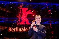 Der norwegische Regisseur und Drehbuchautor Dag Johan Haugerud steht mit dem Goldenen Bären für den besten Film nach der Preisverleihung der Berlinale-Abschlussgala auf dem Roten Teppich. - © Christoph Soeder/dpa