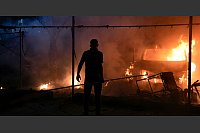 Nahostkonflikt - Gaza: Ein Mann schaut nach einem israelischen Angriff auf ein Feuer. - © Abdel Kareem Hana/AP/dpa