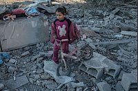 Ein Mädchen rettet ihr Fahrrad nach israelischem Bombardement im Flüchtlingslager Al-Maghazi im zentralen Gazastreifen. - © Rizek Abdeljawad/XinHua/dpa