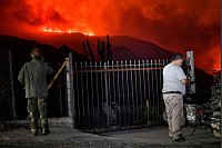 Flammen färben den Himmel glutrot. - © Uncredited/AP