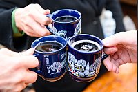 Drei Besucher stoßen in Hamburg mit Glühwein an. - © Jonas Walzberg/dpa