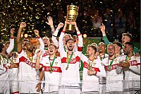Stuttgarts Atakan Karazor hält die Trophäe in die Höhe und jubelt mit seinen Mitspielern über den Pokalsieg. - © Tom Weller/dpa