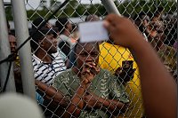 Eine angolanische Migrantin schaut auf einen panamaischen Offizier in Lajas Blancas, nachdem sie den Darien Gap von Kolumbien aus überquert hat, in der Hoffnung, die USA zu erreichen. - © Matias Delacroix/AP