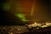 Polarlichter leuchten am frühen Donnerstagmorgen am Himmel über Häusern in Nuuk, Grönland. - © Emilio Morenatti/AP/dpa