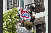 Arbeiter installieren ein Schild zum 50. Jahrestag des Endes des Vietnamkrieges in Ho-Chi-Minh-Stadt. - © Carola Frentzen/dpa