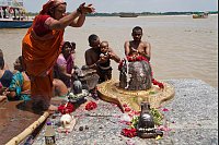 Sharmila und Familienangeh&ouml;rige baden neben einem Symbol von Gott Shiva im Ganges, nachdem sie dort auch die Asche ihrer Angeh&ouml;rigen versenkt haben. - &copy; Anne-Sophie Galli/dpa