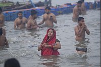 Hinduistische Gläubige nehmen am Neumondtag während des Maha Kumbh Mela Festivals ein heiliges Bad am Ufer des Sangam. - © Deepak Sharma/AP/dpa