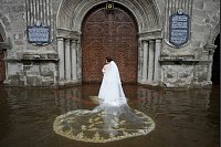 Der Saum des Brautkleides und der Schleier der Braut waren völlig durchnässt. - © Aaron Favila/AP/dpa