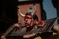 Einige Tierschützer demonstrieren als im Pranger steckend, mit Hörnern und roter Farbe im Gesicht. Damit wollen sie auf das Leiden der Kampfbullen bei den Stierhatzen und der Stierkämpfe während des Sanfermín-Festes in Pamplona aufmerksam machen. - © Alvaro Barrientos/AP/dpa