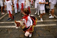Beim Sanfermín-Fest «reitet» ein kleiner Junge bei einem Umzug mit. - © Alvaro Barrientos/AP/dpa