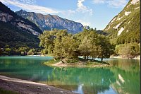 Im türkisblauen Wasser des Lago di Tenno liegt diese winzige, bewaldete Insel. - © Ute Müller/dpa-tmn