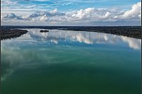 Wolken spiegeln sich im Markkleeberger See in Sachsen. - © Jan Woitas/dpa