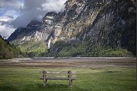 Eine Bank steht am Klöntalersee, einem Stausee der Axpo, bei niedrigem Wasserstand nach dem Winter. - © Gian Ehrenzeller/KEYSTONE/dpa