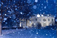 Schnee fällt auf das beleuchtete Weiße Haus in Washington. - © Alex Brandon/AP/dpa