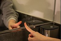 Fingertest und Fazit: Der Hack funktioniert nicht - trotz der Behandlung mit dem Spray erscheinen Fingerabdrücke am Spiegel. - © Christin Klose/dpa-tmn